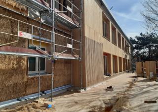 Un bâtiment en construction, bardé de bois