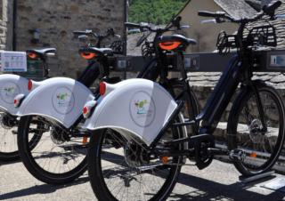 Vélos sur un parking à vélos près d'un muret de pierres sèches