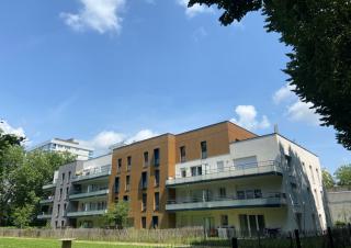 Bâtiment moderne d'habitation de quatre étages avec balcons et jardins