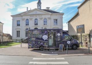 Un camion noir garé devant un bâtiment classique sur lequel on peut lire "Hôtel de Ville"