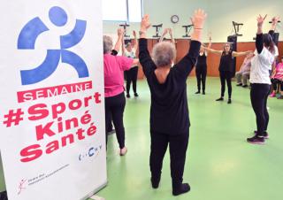 Des femmes en habit de gymnastiques se tiennent en cercle, bras levés vers le ciel