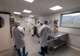 Des personnes en blouse blanche se tiennent dans un laboratoire alimentaire