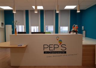 Vue sur une banque d'accueil sur laquelle on peut lire "pep's in champagne"