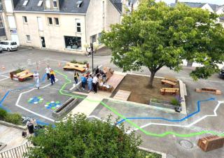 Vue du ciel d'une place sur laquelle sont tracées des lignes bleues, blanches et vertes