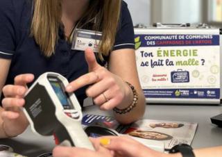Une personne désigne l'écran numérique dun outil de mesure. En fond on peut lire "ton énergie se fait la malle?"
