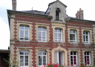 Façade d'un bâtiment du début du XXe siècle, briques rouges et larges fenêtres