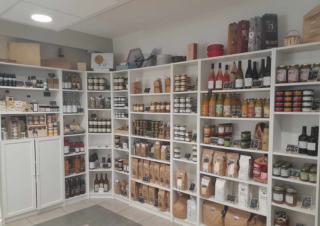 Dans une salle aux murs blancs, rayons garnis de différents produits