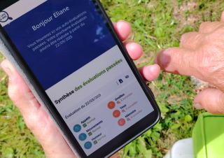 Une dame regarde l'application icope