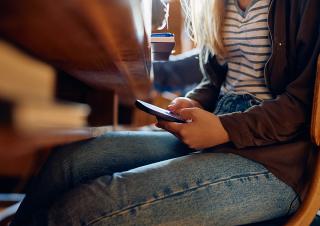 une collégienne consulte son télephone en classe 