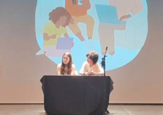 Deux enfants sur une scène avec un visuel relatif aux écrans derrière eux