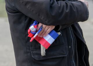 un maire tient son écharpe dans la main 
