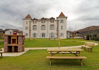 Un château avec au premier plan une pelouse traversée par un chemin de sable