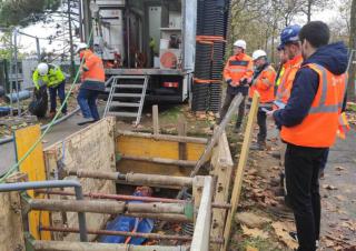 Des hommes en tenue de chantier se tiennent autour d'un trou