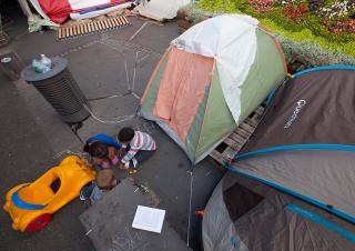 des enfants jouent devant leur tente dans la rue 
