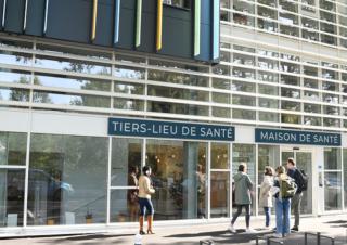 Facade moderne sur laquelle on peut lire "Tiers lieu de santé" et "maison de santé"