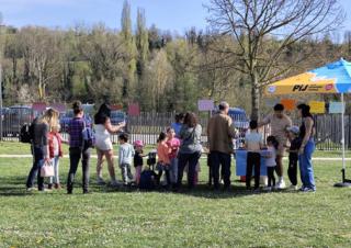 Des personnes se rassemblent autour d'un parasol sur une pelouse