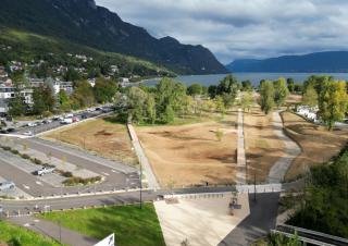 Vus du ciel: un parc, un parking, et en fond une colline et une étendue d'eau