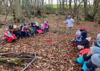 Des enfants assis en cercle dans une forêt