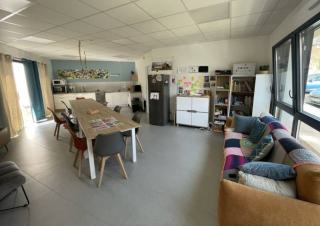 Un salon - cuisine, équipé de table et canapé