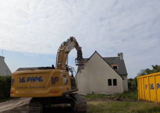 Un tractopelle devant une maison