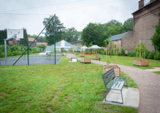 Un jardin avec un terrain de basket et des bacs de plantation