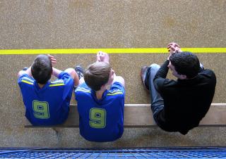 2 garçons sur le banc de touche lors d'un match de handball