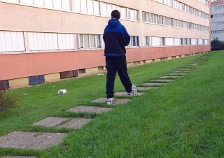 Un adolescent marche dans une cité hlm 