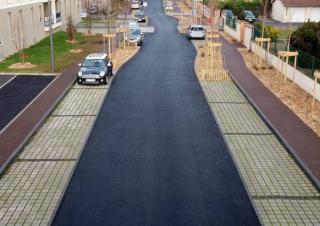Vue d'une rue nouvellement aménagée: plantations et enrobé visiblement neufs