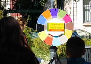 Un panneau rond sur lequel on peut lire "université du citoyen"