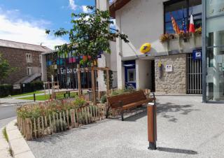 Vue d'une placette équipée d'un banc, devant un bureau de poste