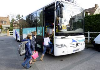 des enfants rentrent dans un car scolaire 