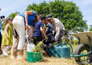 Adultes et enfants s'affairent sur des plantations sur de la paille