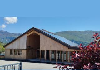 Vue d'un vaste batiment type chalet, avec un toit constitué de deux grandes pentes