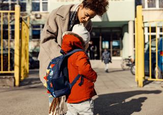 une mère aec son enfant devant l'ecole 
