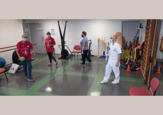 Des personnes machent en cercles dans un gymnase. Elles portent un masque chirurgical sur le visage