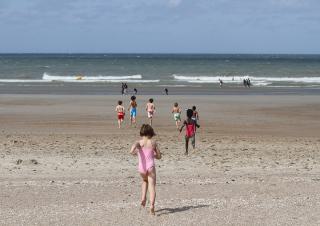 un groupe d'enfants court vers la mer 