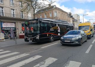 un bus biogaz , une voiture et une camionette en ville  