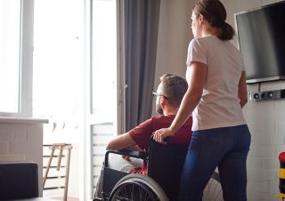 un homme  en fauteuil roulant chez lui 