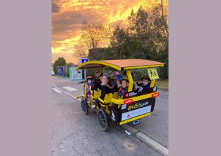 Des enfants dans un véhicule hybride, entre le vélo et le bus