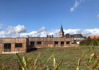 Un bâtiment d'habitation de plain pied, avec un façade bardée de bois