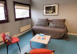 Une salle meublée d'un canapé, une table basse et deux chaises