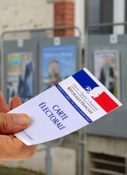 carte electorale devant des panneaux electoraux 